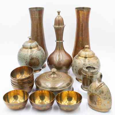 Peacock dish set: The image displays an elegant arrangement of brass items, including a peacock dish set, ashtray, cowbell, vases, and urns, each intricately designed with ornate patterns.