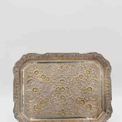 Tray from the coffee service given to the Jordans by Sheikh Ahmad Al-Jaber Al-Sabah.: Image of the silver tray decorated with debossed vines and gold debossed flowers.