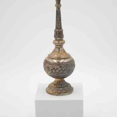 Rose water sprinkler from the coffee service given to the Jordans by Sheikh Ahmad Al-Jaber Al-Sabah.: Image of the silver rose water sprinkler decorated with debossed flowers, leaves, and vines. The gold detail on the leaves is faded.