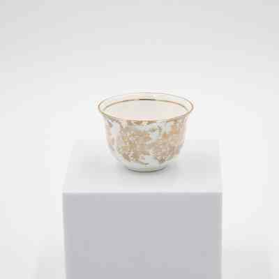 Small cup from the coffee service given to the Jordans by Sheikh Ahmad Al-Jaber Al-Sabah.: Image of a small bone China handle-less teacup decorated with gold foil flowers and leaves. There is a thin gold foil line on the inside rim.