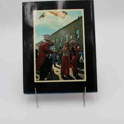 Back cover of "The Sunday Times Book of Jubilee Year": The back cover features British citizens in patriotic colors, celebrating with each other. A British flag waves above them along with other patriotic decorations.