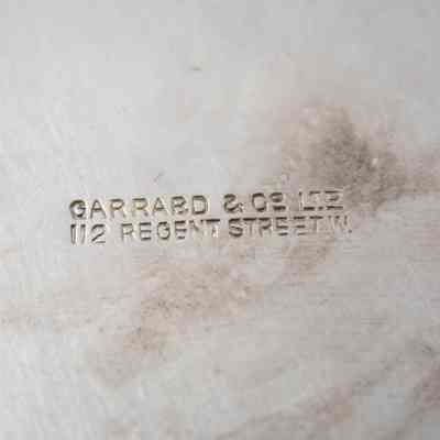Stamped company name on the bottom of the silver trophy cup given to Mrs. Jessie Jordan.: Up close image of the stamped company name on the bottom of the trophy cup, "GARRARD & CO LTD 112 REGENT STREET W."