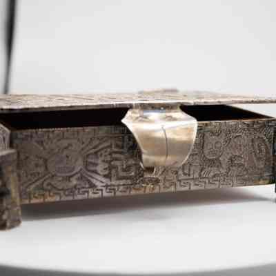 Cigarette box: The Peruvian silver cigarette box features intricate Incan-style mythological engravings, including mythic figures
