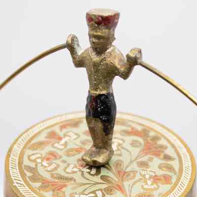 Acrobat: The acrobat has little detail, his pants are black and his hat is red. The platform he stands on is light blue with red and brass flowers.