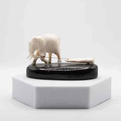 Carved Ivory Elephant Pulling Log on Black Stone Base