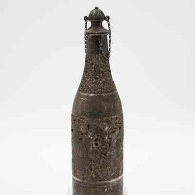 Silver bottle-shaped decanter with chain-attached lid.: Image of the silver bottle-shaped decanter with chain-attached lid. The decanter is engraved with scenes of a Persian Banquet of Song and Dance.