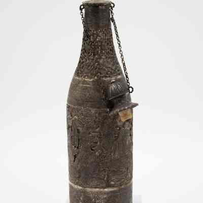 Silver bottle-shaped decanter with chain-attached lid.: Image of the silver bottle-shaped decanter with chain-attached lid. The decanter is engraved with scenes of a Persian Banquet of Song and Dance.