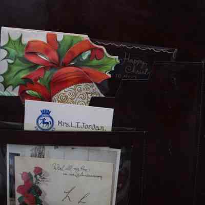 Items inside desk mat: Different small cards, one dedicated to "Mrs. L.T. Jordan." and one signed "L.L."