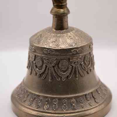 Bell: The brass Tibetan ritual prayer bell features intricate engraved designs and a crown-shaped handle.