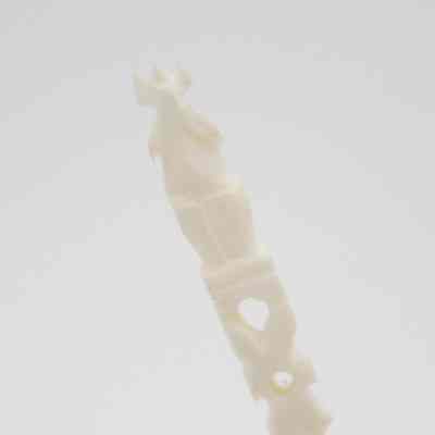 The end of one of the skewers.: Up close image of the end of one of the skewers. It depicts an anamorphic figure.