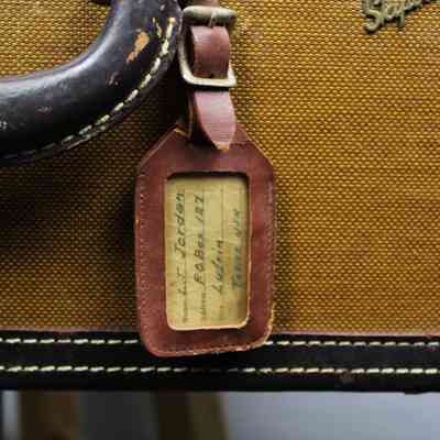 Luggage tag: A red, leather luggage tag with "L.T. Jordan; P.O. BOX 127, Lufkin, Texas, USA."