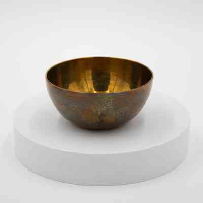 Peacock bowl: A brass bowl with an intricate peacock design sits.