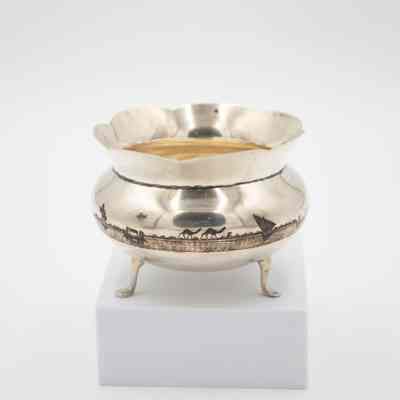 Footed bowl: A silver footed bowl features an etched oasis scene, depicting camels and palm trees.