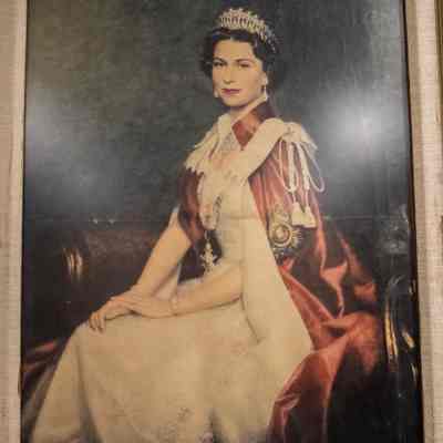 Close up of Elizabeth II: A framed portrait of Queen Elizabeth II in a red and white gown.