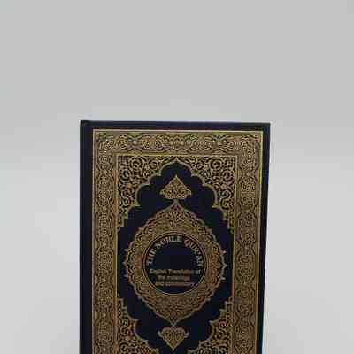 Front Cover of "The Noble Quran": The Front Cover of "The Noble Quran" features a yellow Islamic ornamental design on black leather. In the middle is a circle with the title and subtitle of "Interpretation of the Meanings of the Noble Qur'an in the English Language" in English.