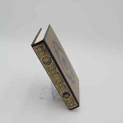 Book spine of "The Noble Quran": The book spine of "The Noble Quran" has an ornamental design as well as the title in both Arabic and English.