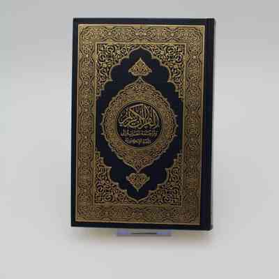 Back Cover of "The Noble Quran": The back cover of "The Noble Quran" features the same yellow on black ornamental design as the front cover. The title and subtitle is again in the middle, but it is in Arabic.