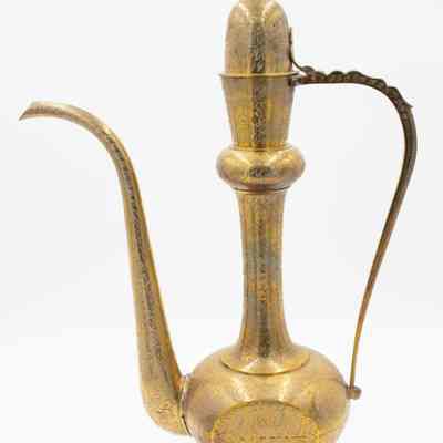 Brass ewer: The image displays a single ornate brass Aftaba ewer with intricate engraved floral patterns, featuring a long spout and a curved decorative handle.
