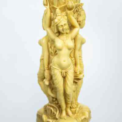 Women on pedestal: The woman on the pedestal wears jewelry and pants, holding up the layer in the pedestal above her with goats.