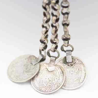 Silver coins pendant: The other side of each coin that had the Great Seal of the United States. This side has an Arabic silver coin.