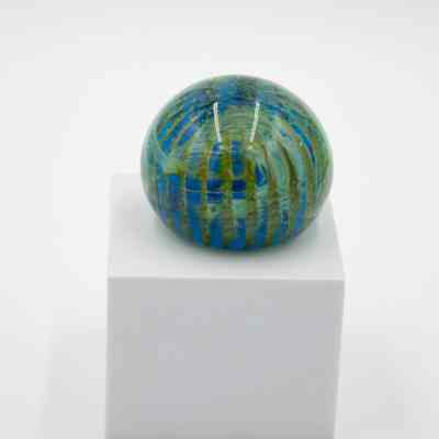 Blue and Green Round Glass Paperweight: The other side of the paperweight. This side has more green and is less translucent from the blue. The green swirls around and is lighter in color than the other side.