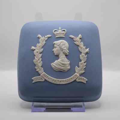 Blue Wedgwood Jasperware square box with white bust of Queen Elizabeth II: The top of the powder blue box, has a side profile bust of Queen Elizabeth II. She has a crown floating above her head, surrounded by a wreath with "H.M. QUEEN ELIZABETH II JUNE 1953" in a banner at the bottom.