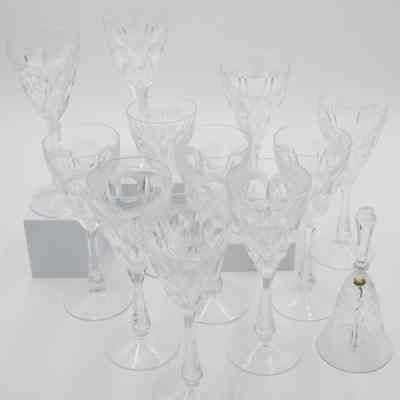 Wine glasses and dinner bell: The image displays eleven elegant Venezuelan crystal-cut wine glasses, each with intricate patterns, accompanied by a similarly designed dinner bell.