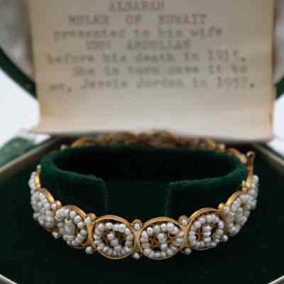 Gold and pearl bracelet in green case given to Mrs. Jessie Jordan by Umm Abdullah Mubarak.: Image of the bracelet made of gold wire strung with Kuwaiti recede pearls arranged in circles.