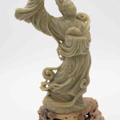 One of the large carved soapstone figurines on a carved base from Bali.: Image of one of two of the carved soapstone figurines. This one depicts a man dancing.