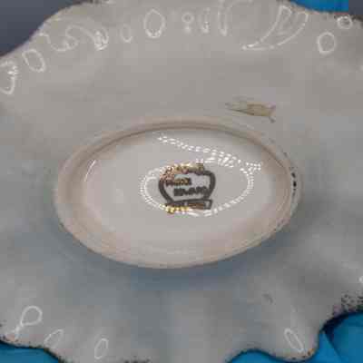 Bottom of dish with company logo.: The bottom of the dish has a gold label identifying the work as “Prince Edward Fine China”