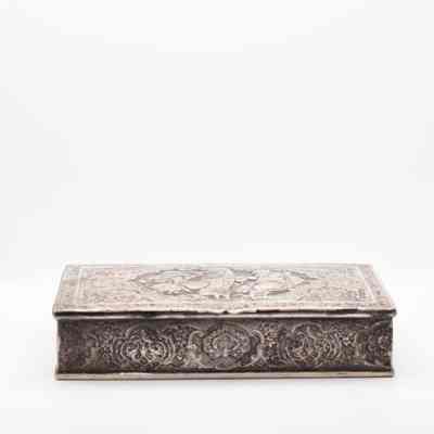 Side of silver repousse box from Persia.: Image of the side of the silver repousse box. The box is intricately decorated with Middle Easter-style swirls and leaves.