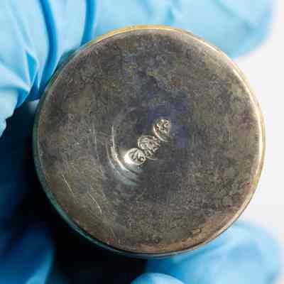 Bottom of one of the Persian silver salt and pepper shakers.: Up close image of the bottom of one of the silver salt and pepper shakers. It is stamped with three maker's marks. The marks contain Arabic script and are illegible.