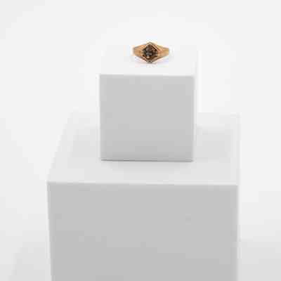 L.T. Jordan's Floresville High School 1923 class ring.: Image of L.T.'s ring sitting on a white block. It is bronze with a large "F" in the center with the words "HIGH SCHOOL" around.