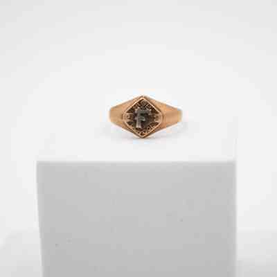 L.T. Jordan's Floresville High School 1923 class ring.: Up close image of L.T.'s ring sitting on a white block. It is bronze with a large "F" in the center with the words "HIGH SCHOOL" around.