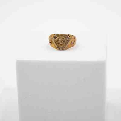 Jessie Wright Jordan's Lufkin High School 1925 class ring.: Up close image of Jessie's ring sitting on a white block. It is gold. There is a panther head in the center and "L.H.S" around the center.