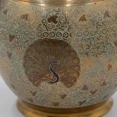 Peacock urns: The brass urn features an intricate design of blue peacocks amidst detailed floral patterns.