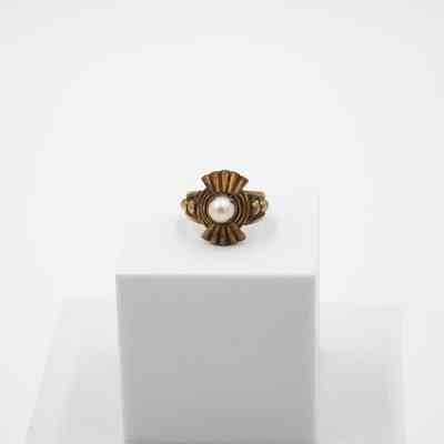 Gold and pearl sunburst ring that belonged to Mrs. Jessie Jordan.: Image of the gold pearl ring with a sunburst 50's design and large pearl in the center.