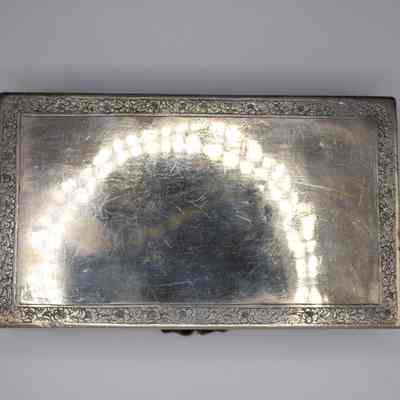 Bottom of the silver repousse box from Persia.: Image of the bottom of the silver repousse box. The bottom is relatively blank with flower and leave designs in a border around the outside.