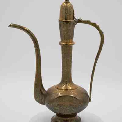 Brass ewer: The image shows an elegant, intricately designed brass aftaba ewer with a long spout and ornate handle,