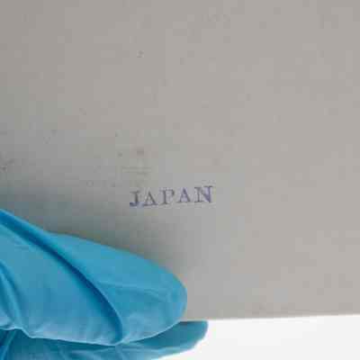 Back of the Japanese "Little Fork" set box.: Up close image of the back of the original cardboard box that holds the set of 12 little forks. It is white and there is a blue stamp that reads "JAPAN."