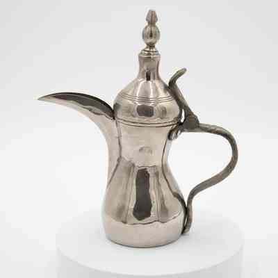 Pewter coffee urn: The image depicts a pewter coffee urn with an ornate spout and handle.