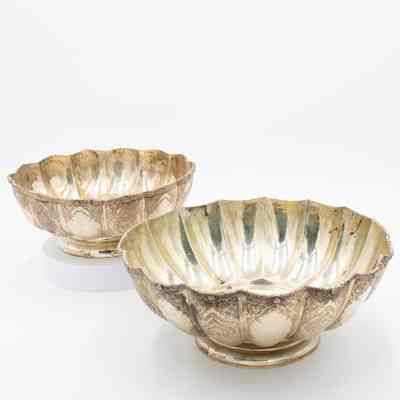 Large and small scalloped bowls: Two intricately etched silver scalloped bowls, one larger and one smaller.