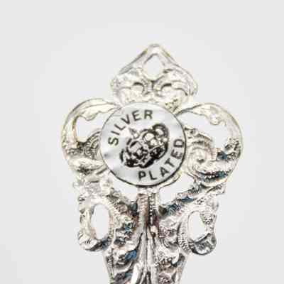 Back of the handle of one of the silver plated spoons.: Up close image of the back of the end of the handle. There is a silver sticker with black text that reads "SILVER PLATED" with an image of a crown.