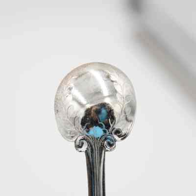 Back of the bowl of one of the silver plated spoons.: Up close image of the back of the bowl of one of the silver plated spoons. It is decorated with a leaf design.