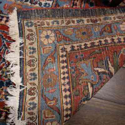 Red and blue area rug: The image shows the intricate backside of a large red and blue area rug.