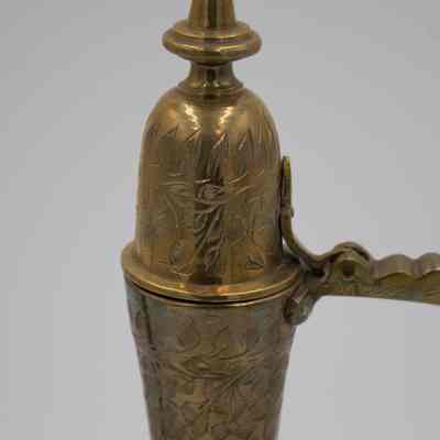 Ewer lid: The brass aftaba ewer displays intricate floral engravings on its lid and body.