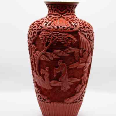 Cinnabar vase: The small red cinnabar vase features intricate carvings and a vibrant blue enamel interior.