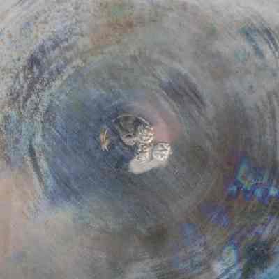 Back of one of the six round Persian silver dishes. It is stamped with an Arabic maker's mark.: Up close image of the back of one of the round Persian silver dishes. There is a maker's mark stamped on the dish with Arabic script.