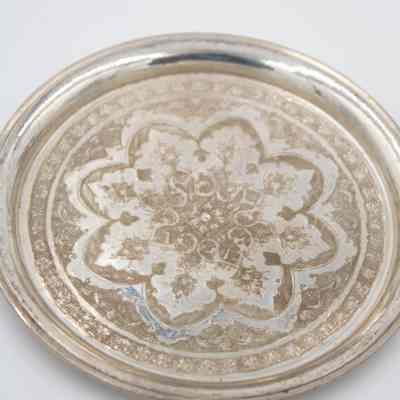 One of the six round Persian silver dishes engraved with floral mandala design.: Image of one of the round Persian silver dished engraved with a floral mandala design.