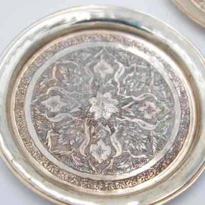 One of the six round Persian silver dishes engraved with floral mandala design.: Image of one of the round Persian silver dished engraved with a floral mandala design.
